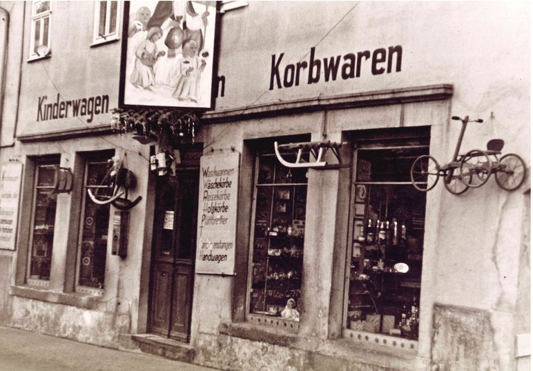 Schwarzweißfotografie des Geschäftes Spielwaren-Fritzsche, Schaufenster mit Auslagen, Aufschrift Kinderwagen, Korbwaren