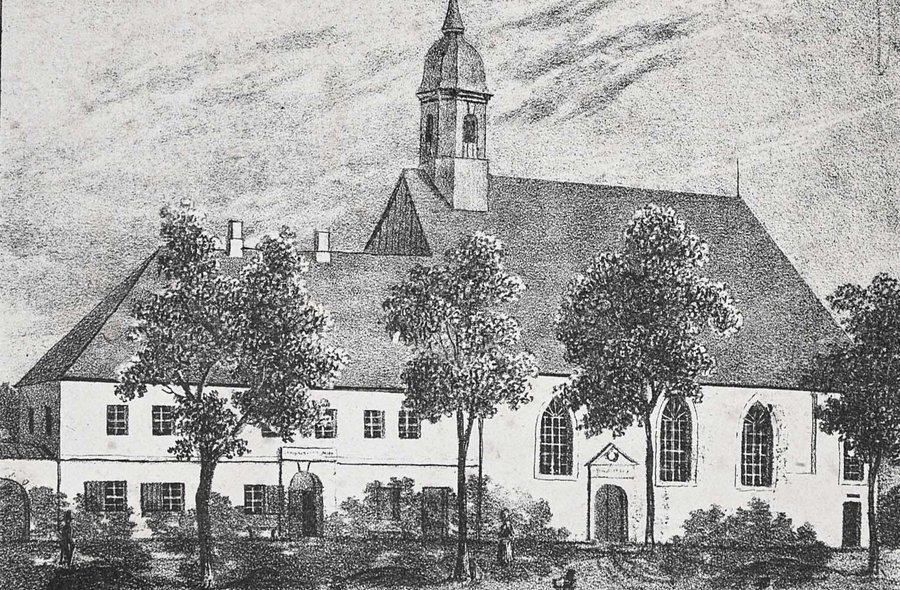 Die historische Schwarzweiß-Grafik zeigt eine Außenansicht der Kirche, davor eine Mauer und ein Weg, auf dem zwei Personen und eine Frau mit Kinderwagen spazieren.