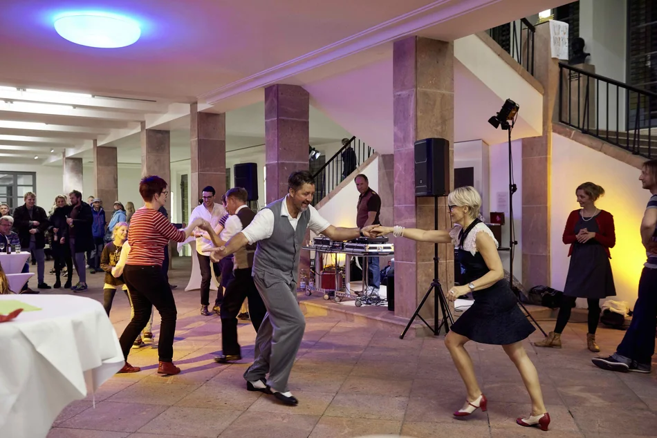 Im Foyer eines Museums tanzen einige Menschen Swing.