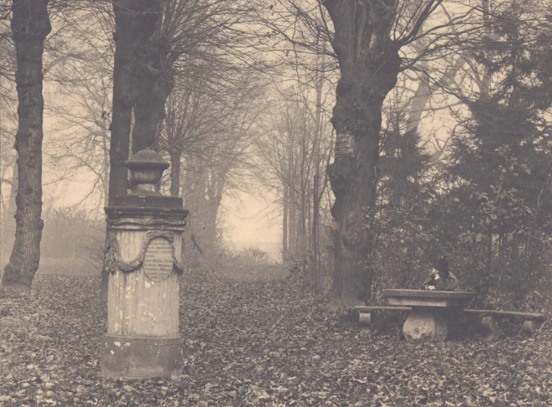 Historische Fotografie einer Baumallee auf einer Elb-Insel bei Coswig mit Denkmal links und sitzendem Mann rechts