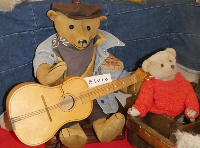 Ein von Dorothea Siegel gefertigter Teddybär mit Gitarre namens Elvis sitzt neben einem kleineren Teddybär.