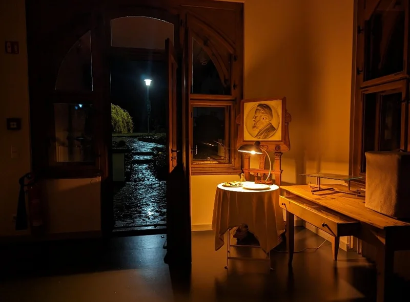 Blick aus einem schummrig beleuchteten Ausstellungsraum des Museums im Wilhelm Ostwald Park hinaus in die Nacht