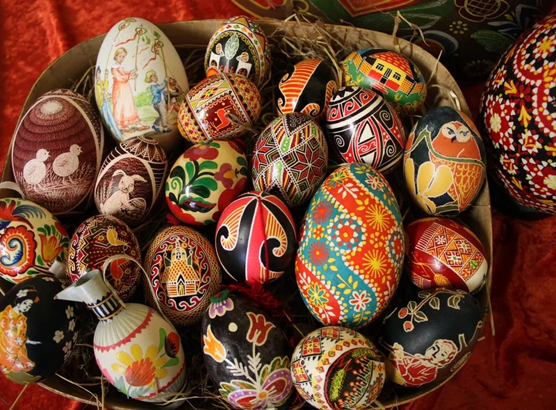 In einem Körbchen liegen bunte, kunstvoll bemalte Ostereier mit gegenständlichen wie auch rein dekorativen Verzierungen.