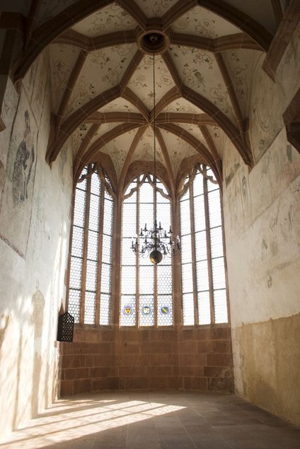 Blick aus dem Inneren der Kapelle in ein hohes, leeres, lichtdurchflutetes Kirchenschiff mit Kreuzgewölbe.