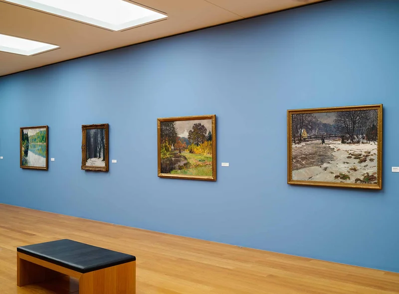 Fünf impressionistisch anmutende Landschaftsgemälde hängen an hellblauer Wand.