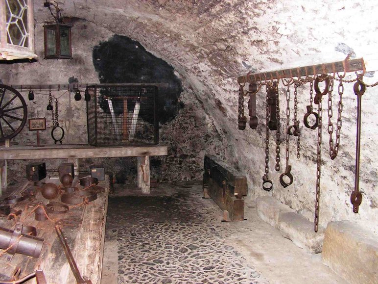 In einem steinernen Gewölbe befinden sich eine Vielzahl eiserner Folterwerkzeuge.