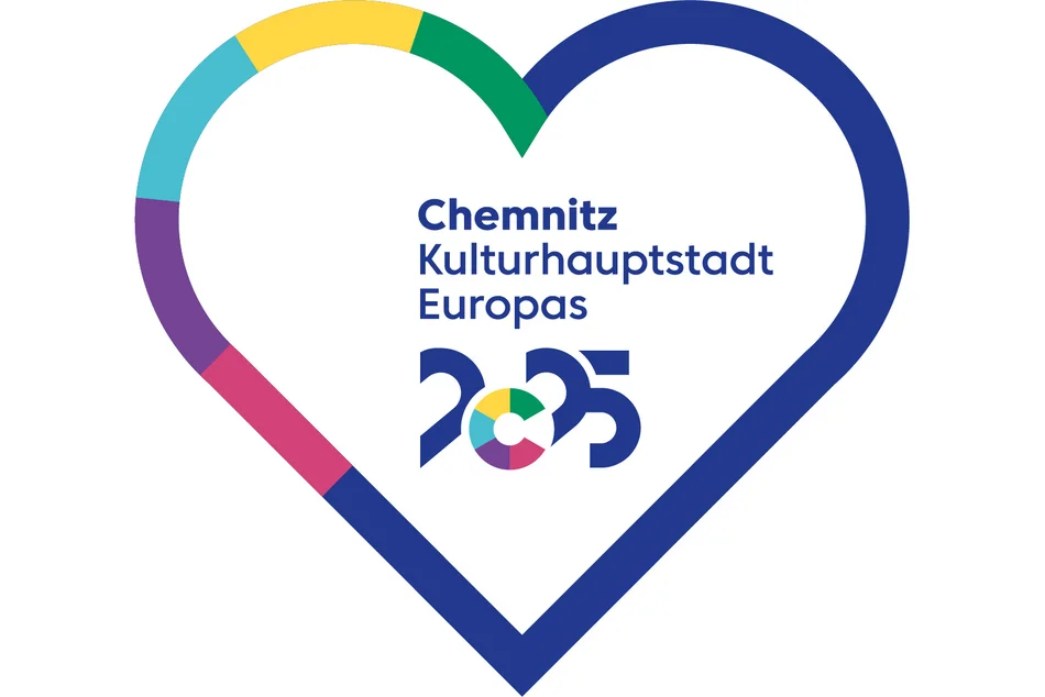 In einem mit einem bunten Rahmen versehenen weißen Herz steht der Schriftzug Zitat "Chemnitz Kulturhauptstadt Europas 2025" Zitat Ende.