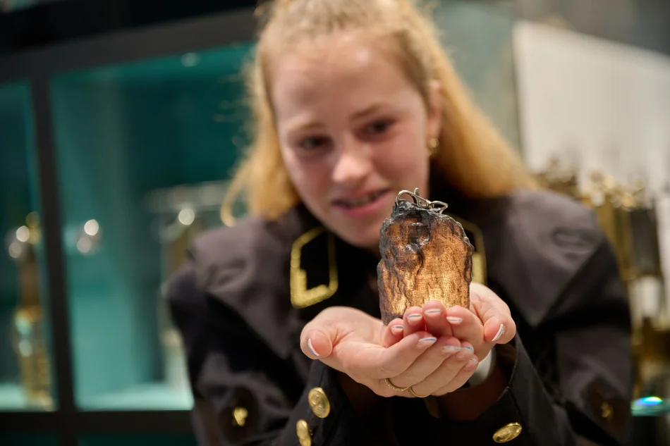 Interaktive Museumsrallye mit dem „glühenden Kohlenstück“ Ein Mädchen hält die Nachbildung eines glühenden Kohlenstücks in der Hand