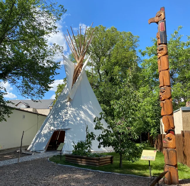 Im Außengelände des Karl-May-Museums in Radebeul stehen ein großes Tipi und ein hoher Totempfahl nach indigenem Vorbild.