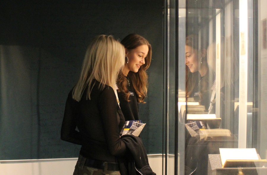 Annaberg-Buchholzer Museumsnacht Zwei Frauen schauen in eine große beleuchtete Vitrine, in der ein aufgeschlagenes Buch ausgestellt ist.
