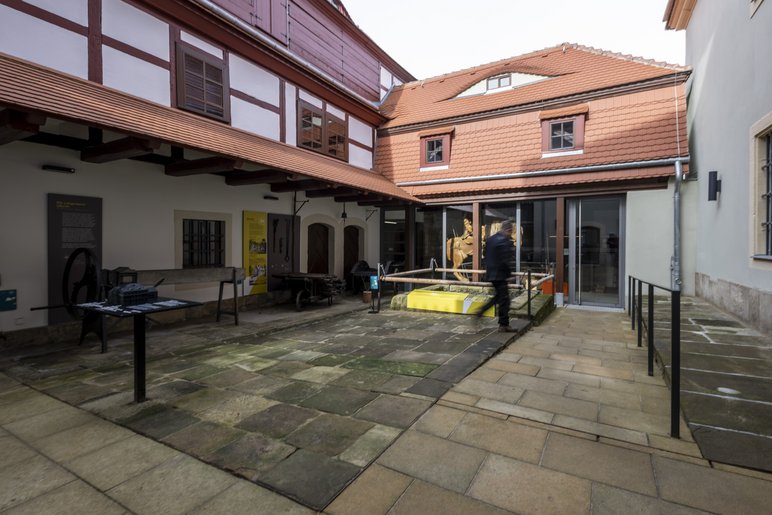 Innenhof des Museums mit Exponaten, Kopfsteinpflaster und historischer Fassade