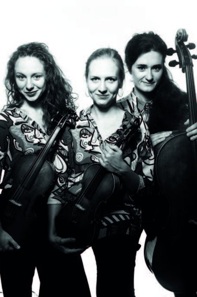 Tansman-Trio Das Foto zeigt das polnische Tansman Trio: Drei Frauen mittleren Alters stehen nebeneinander und halten jeweils ihr Streichinstrument locker in der Hand.