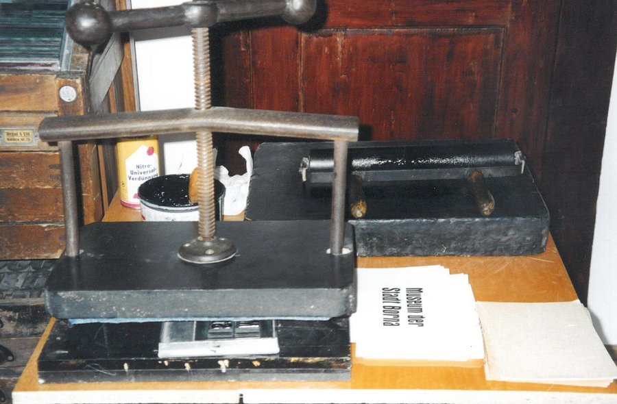 Alte Druckpresse Das Foto zeigt eine alte Druckpresse und ein bedrucktes Papier.