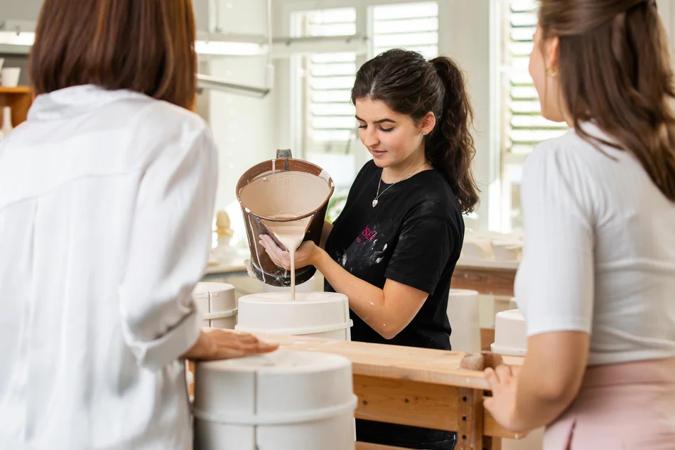 Kreativ-Workshop Gießen bei MEISSEN Im Workshop "Gießen" füllt eine Mitarbeiterin flüssige Porzellanmasse in eine Form – ein anschaulicher Einblick ins Handwerk.