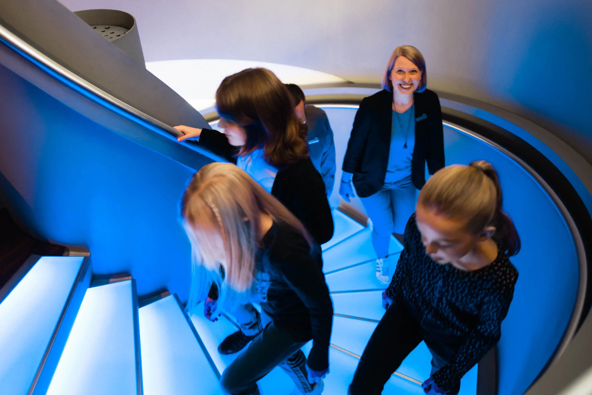 Kindergruppe im Museum Kindergruppe erklimmt die blau beleuchtete Wendeltreppe, genannt Zeittreppe, ins Museum