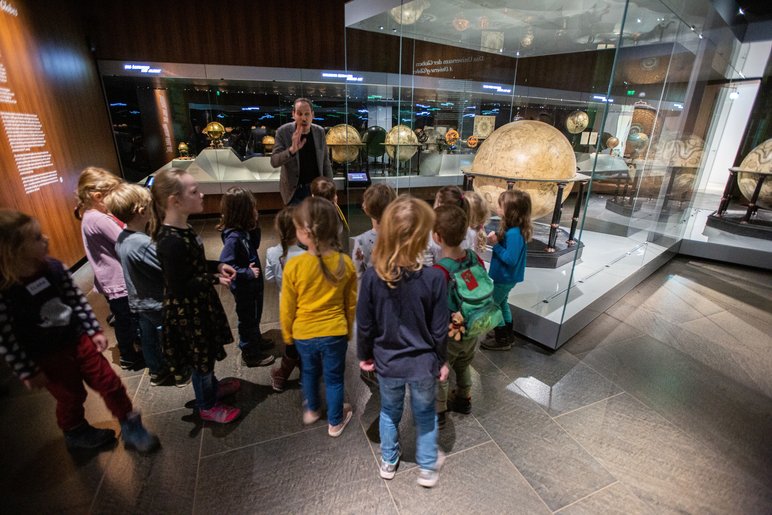 Dieses Foto zeigt eine Gruppe von Kindern bei einem Vermittlungsprogramm im Globensaal des Mathematisch-Physikalischen Salons.