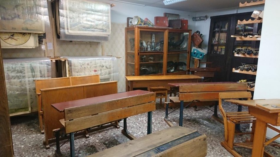 Das Foto gibt einen Einblick in einen mit einer Vielzahl historischer Schulmöbel, Arbeitshilfen und anderen Objekten zu Schule und Unterricht in früheren Zeiten ausgestatteten Raum.
