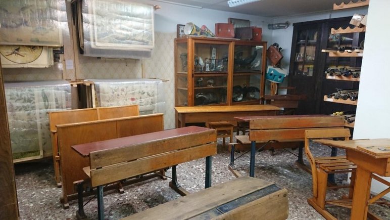 Das Foto gibt einen Einblick in einen mit einer Vielzahl historischer Schulmöbel, Arbeitshilfen und anderen Objekten zu Schule und Unterricht in früheren Zeiten ausgestatteten Raum.
