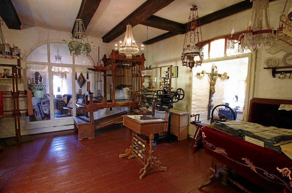 Das Foto zeigt einen Blick in den Ausstellungsraum zum Handwerk des Posamentierens – der „Posamentierstube“ – des Turmmuseums Geyer.