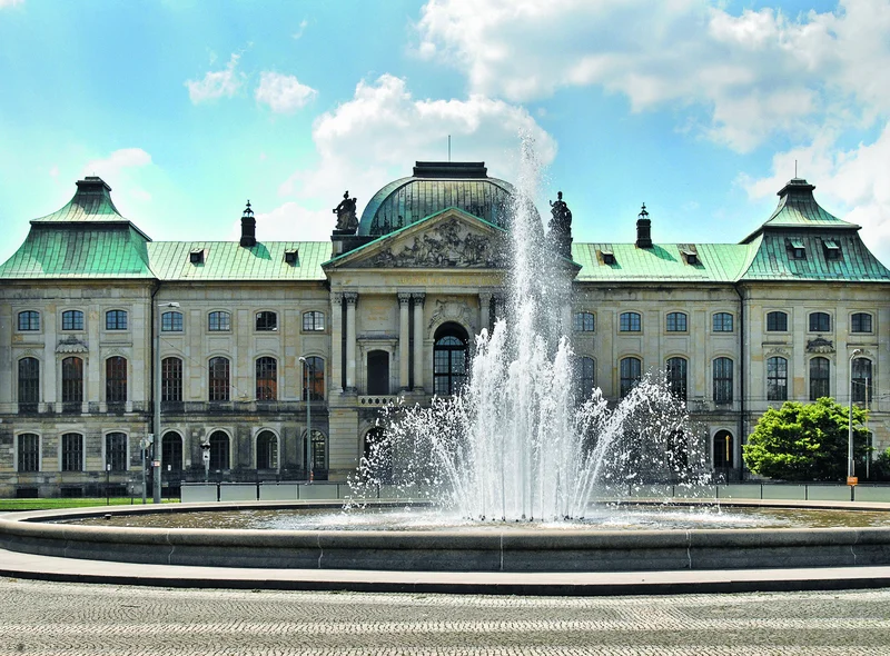 Sommerliche Außenansicht des Japanischen Palais, eines historischen Sandsteingebäudes, davor ein großer Platz mit Fontäne.
