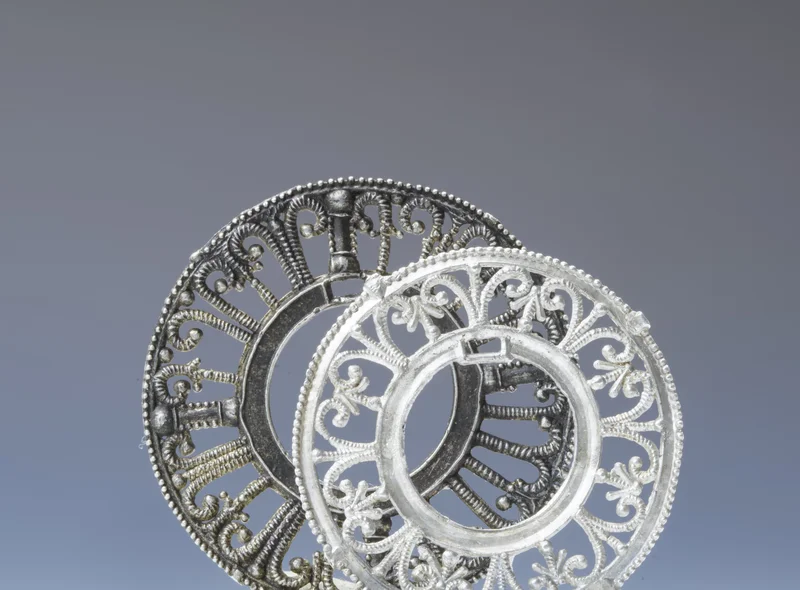 Zwei kreisrunde, verzierte Spangen aus Zinn zum Verschließen des Halsausschnittes von Kleidungsstücken