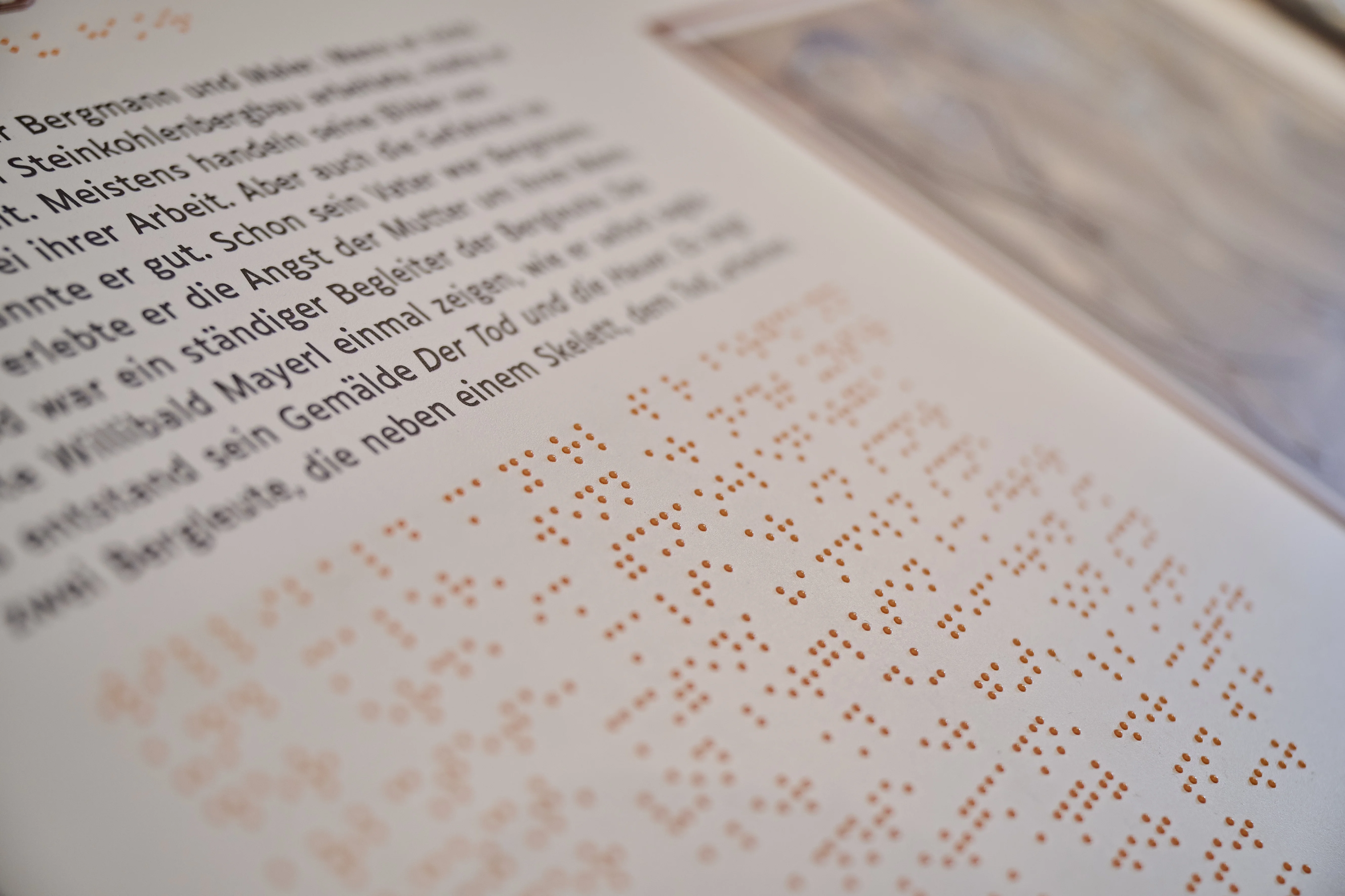 Nahaufnahme einer taktilen Station, der sogenannten Kohleninsel, mit Text in Schwarzschrift und Brailleschrift