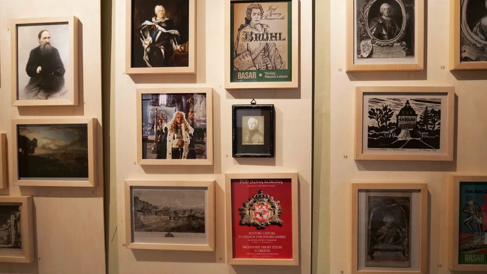 Wand mit einer Vielzahl kleiner, eng beieinander hängender gerahmter Fotos und Grafiken