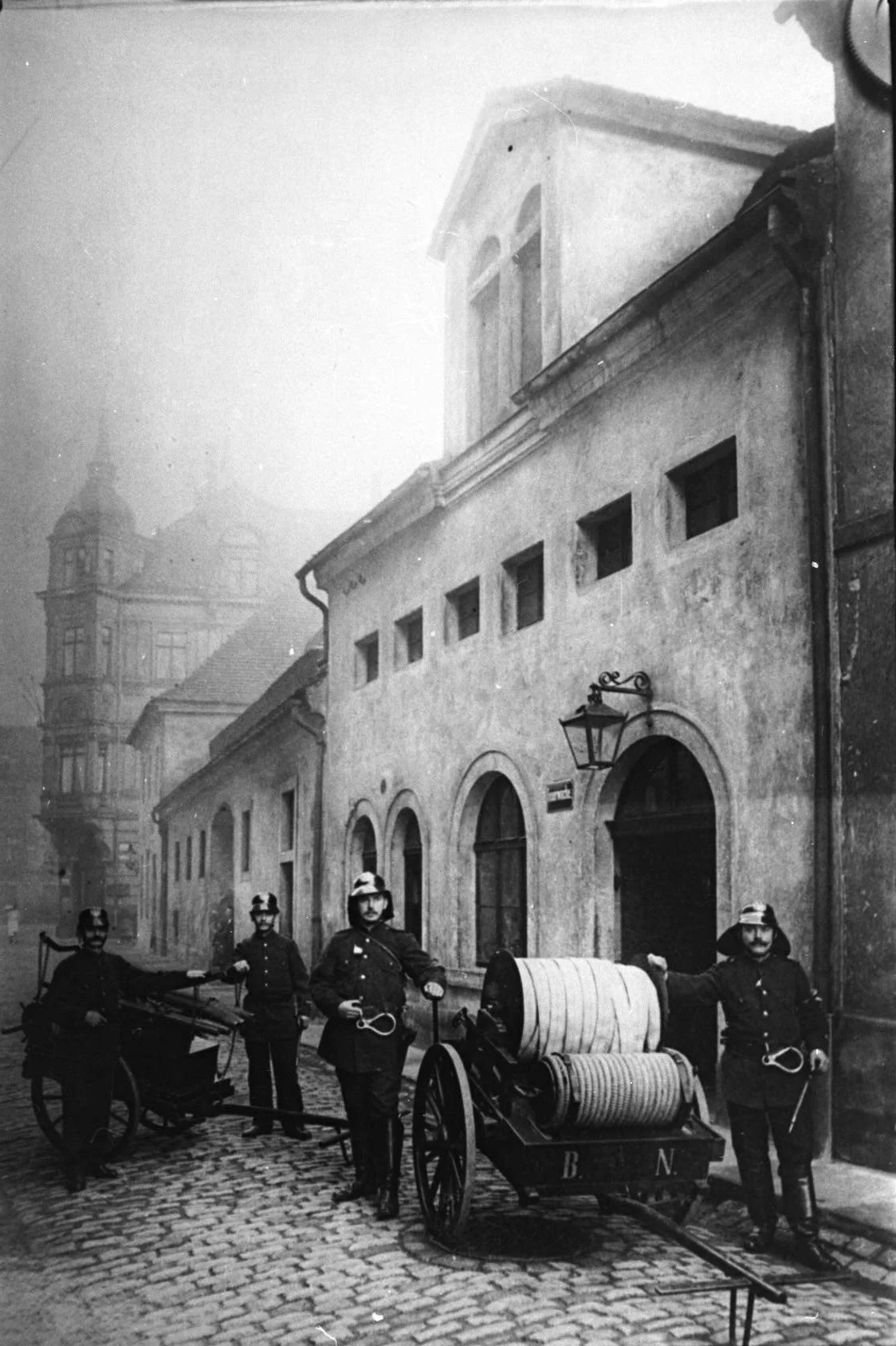 Das historische Foto zeigt Feuerwehrleute mit der damals typischen Löschtechnik.