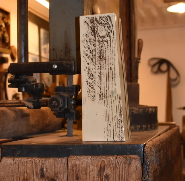 Auf einem Holzblock steht eine Vase mit Holzstruktur.