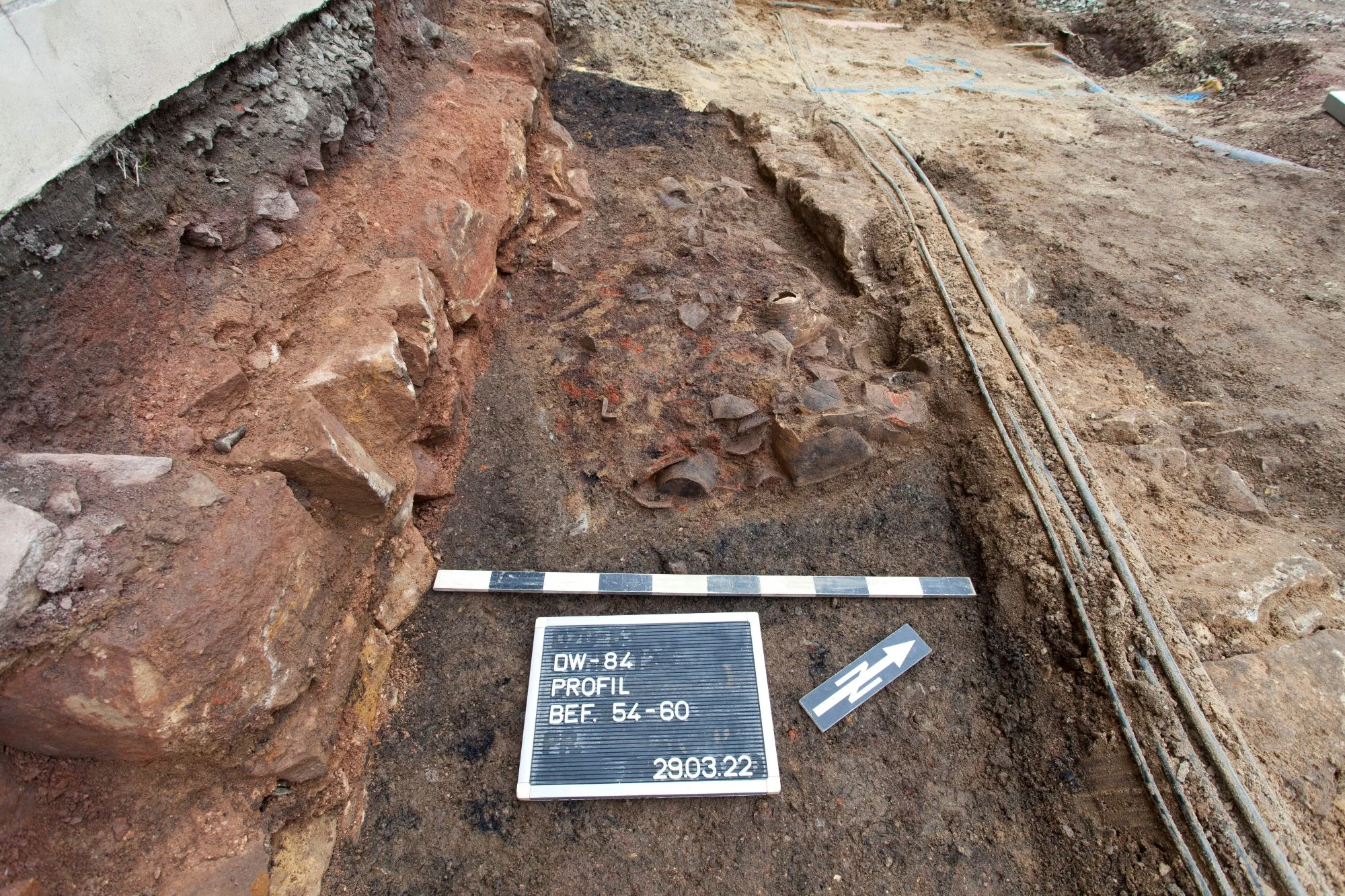 Archäologische Ausgrabung in Dippoldiswalde mit freigelegten Keramikscherben Ausschnitt einer archäologischen Grabungsstelle mit Zollstock, Kennzeichnung und Beschilderung