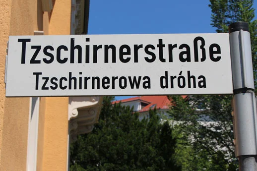 Zweisprachiges Straßenschild der Tzschirnerstraße, deutsch und sorbisch Tzschirnerowa dróha, schwarze Schrift auf weißem Grund