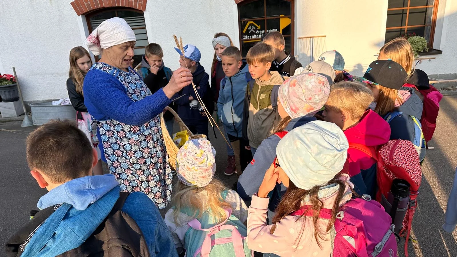 In der historischen Böttcherfabrik gibt es viel zu entdecken: Landwirtschaftsgeräte, Maschinenbauwerkstatt und Landschaftsbilder. Eine Kindergruppe lauscht den Ausführungen zur Fabrikgeschichte, die von einer erwachsenen Person erklärt wird.