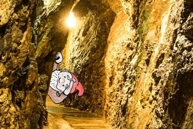 Im Reich des kleinen Bergzwerks Collage eines Bergwerksstollens mit einem Zwerg, der um die Ecke schaut