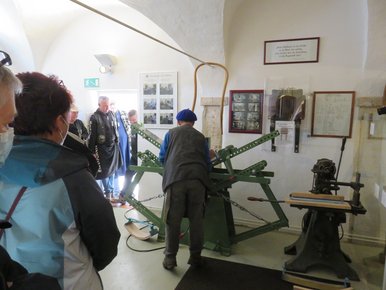 Besucherinnen und Besucher verfolgen die Vorführung eines Handwerkers im Holzbiegen an historischer Maschine