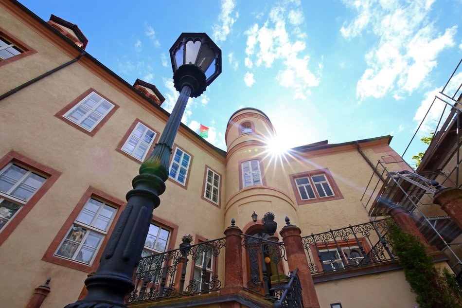 Schlossturm und Freitreppe vom Schlosshof aus betrachtet, im Vordergrund eine historische Laterne