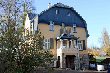Karl Schmidt-Rottluff Haus, Seitenansicht Zweistöckige Villa mit gelber Fassade, Erker, Balkon und dunklem Schieferdach