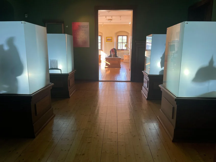 ln einem abgedunkelten Ausstellungsraum sind in vier von innen beleuchteten, mit Milchglas versehenen Vitrinen die Schatten von vier Objekten zu sehen.