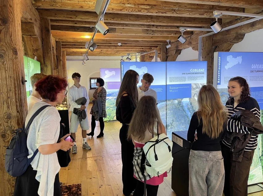 Eine Schülergruppe betrachtet Informationstafeln, Fotos und Objekte im Museum böhmisch-sächsisches Erzgebirge in Marienberg.