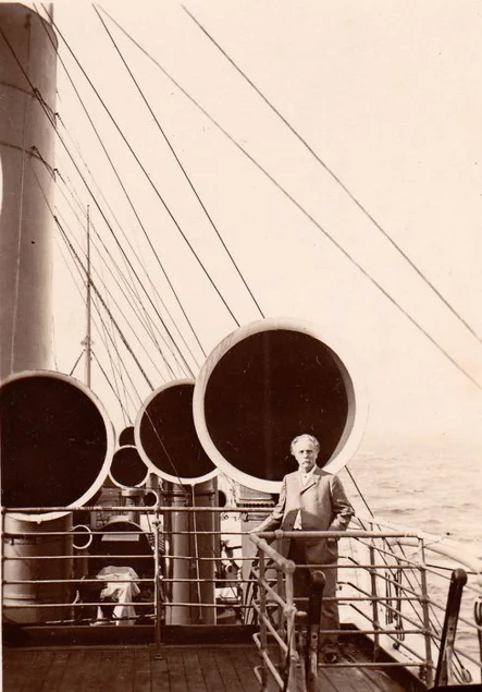 Karl May 1908 bei seiner Überfahrt nach Amerika auf dem Schiff „Großer Kurfürst“ Historisches Foto des Schriftstellers Karl May, elegant gekleidet auf einem großen Schiffsdeck vor den Schiffshörnern stehend