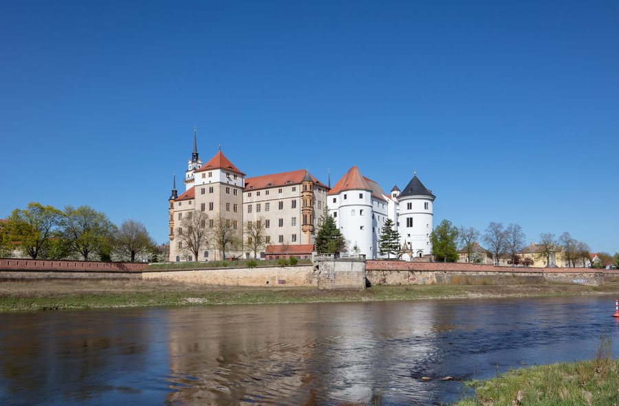 Schloss Hartenfels Foto eines an einem Fluss (der Elbe) gelegenes großes Schloss