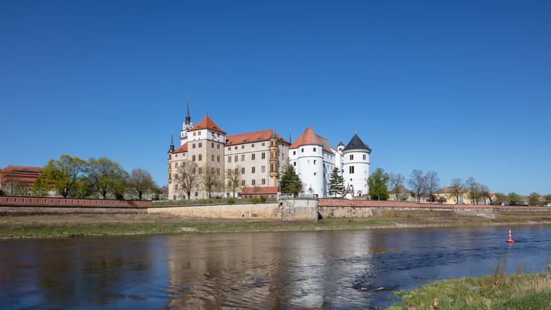 Foto eines an einem Fluss (der Elbe) gelegenes großes Schloss