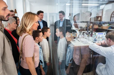 Familienführung im Uhrenmuseum Besucher schauen Uhrmacher bei der Arbeit zu