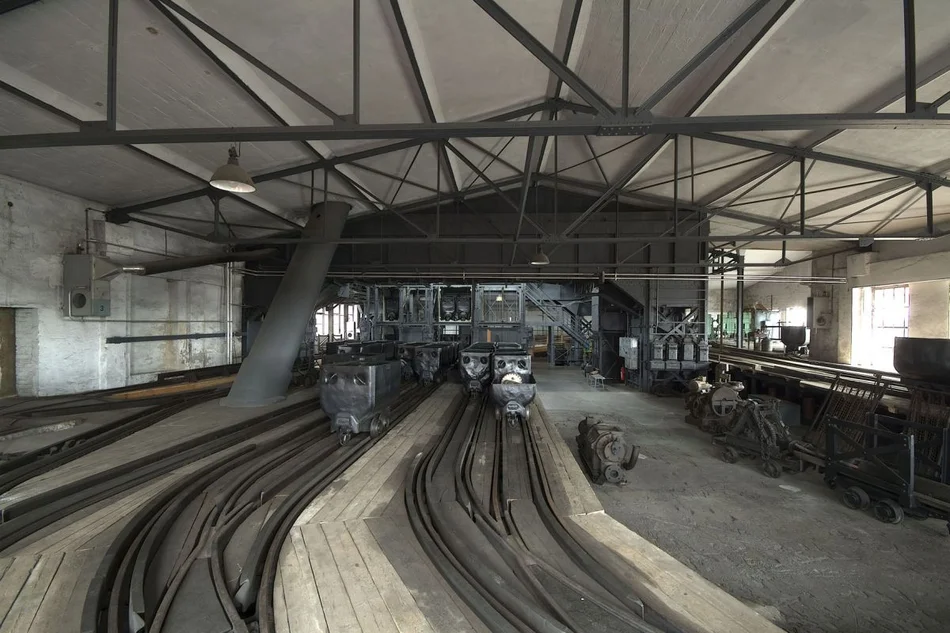 Hängebank im Bergbaumuseum Blick in einen authentischen Raum der ehemaligen Kohle-Förderanlage, auf dessen Boden Schienen verlaufen.