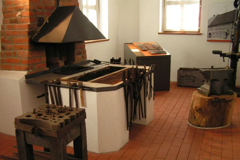Inszenierung mit Schmiede-Ofen, Amboss, Zangen und weiteren Objekten aus einer historischen Schmiede
