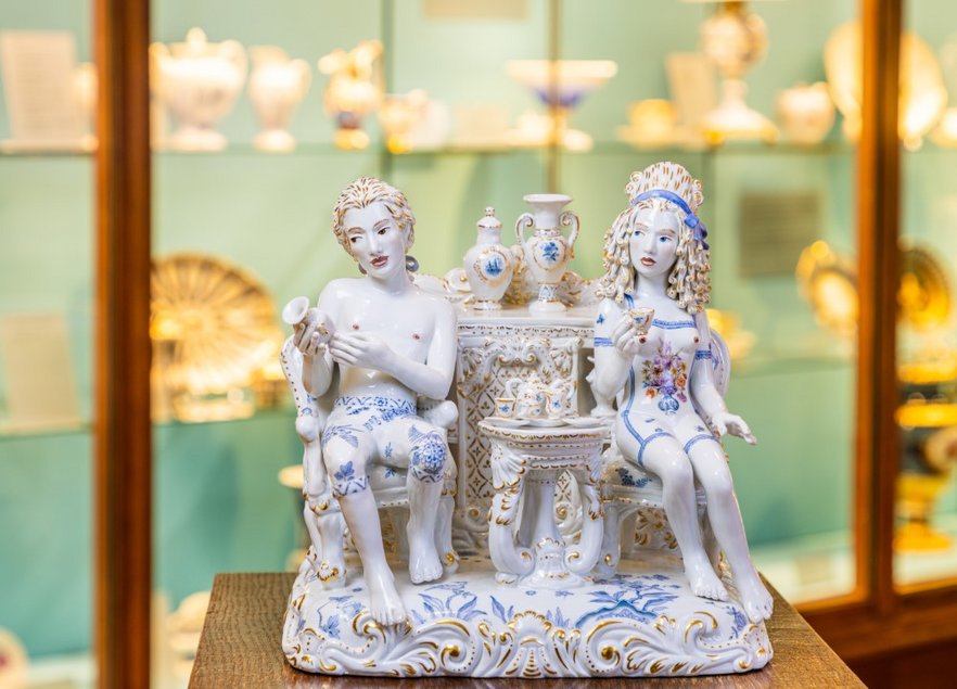 Das Bild zeigt die Figur eines sitzenden Paares in Meissener Porzellan, geschaffen von der amerikanischen Künstlerin Chris Antemann.