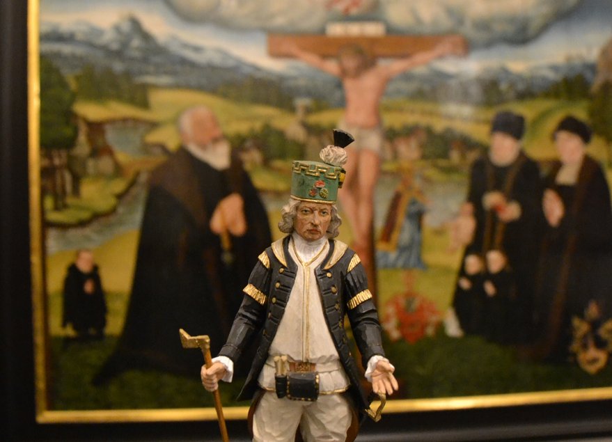 Das Foto zeigt den geschnitzten Paul-Schneider-Bergmann vor einem Lucas-Cranach-Gemälde im Erzgebirgsmuseum.