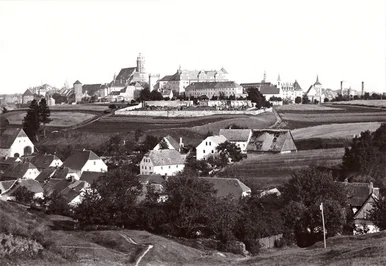 Historische Schwarzweißfotografie von Bautzen. Blick über die Ortschaft Seidau von Nordwest Richtung Südost. Im Hintergrund sind der Protschenberg-Friedhof und die Ortenburg sowie Teile der historischen Altstadt zu sehen.