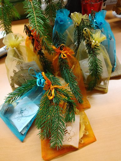 Überraschung! Foto mehrerer bunter Geschenkbeutelchen, die mit kleinen Tannenzweigen verziert sind.