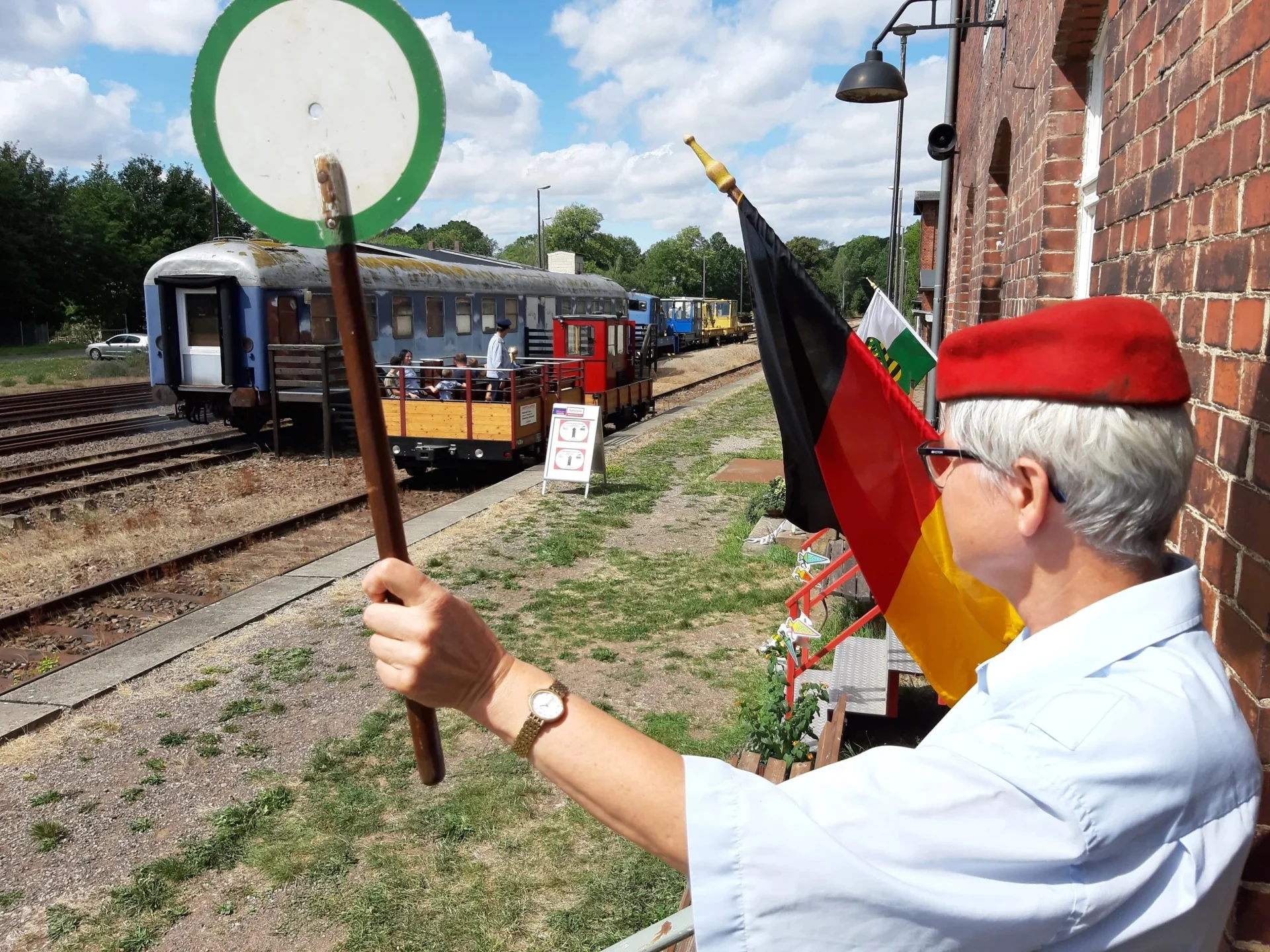 Abfahren! Die Aufsicht schickt den Zug auf Strecke. Die örtliche Aufsicht mit der roten Mütze erteilt dem Chemnitztal-Express den Abfahrauftrag mit dem grünen Befehlsstab.