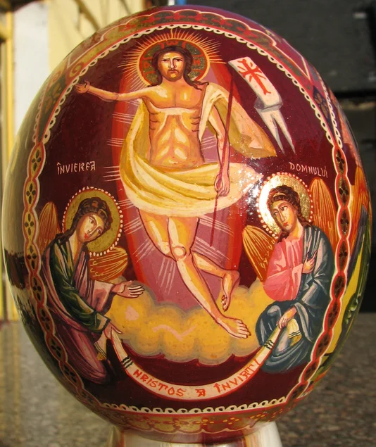 Ein kunstvoll mit Abbildungen von Jesus Christus und zwei Heiligen bemaltes Osterei